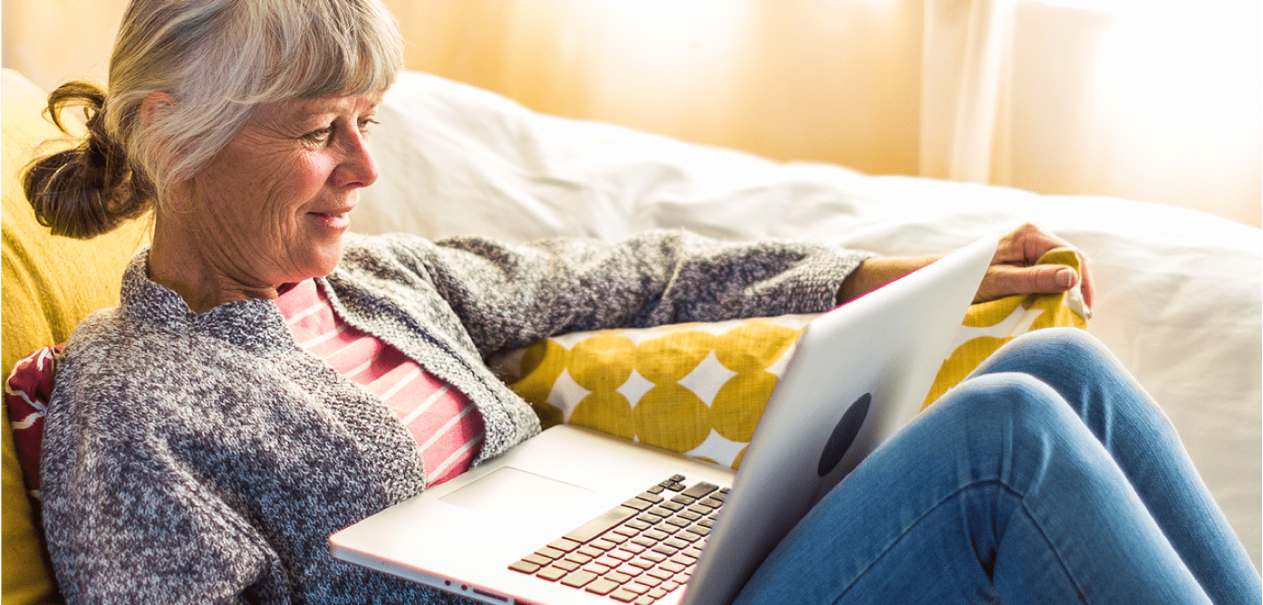 older woman relaxing reading laptop older woman relaxing reading laptop